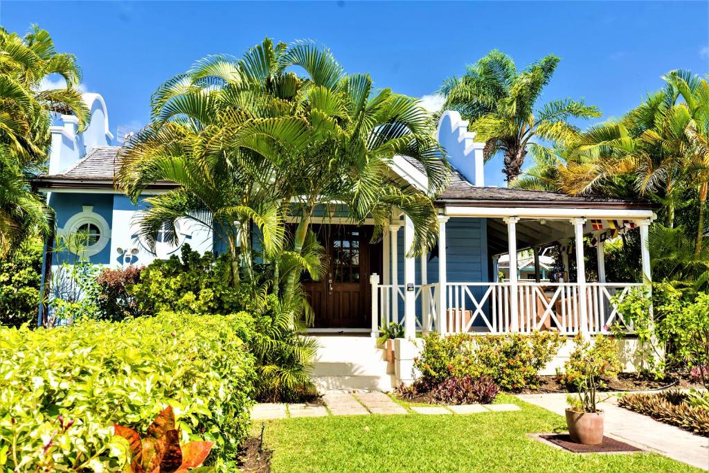 a house with palm trees in front of it at Sandy Lodge, 4 Porters Court in Saint James