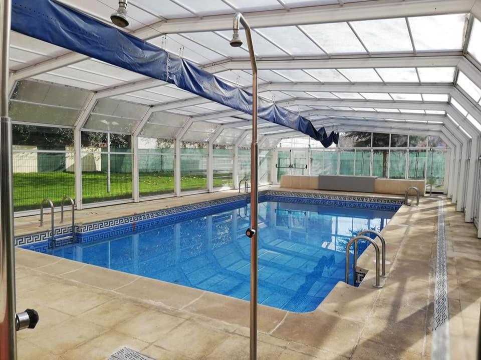 a large swimming pool with a blue tarp over it at Fridda House Atocha Madrid in Madrid