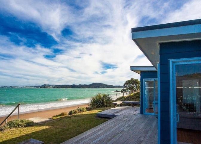 una casa blu con vista sulla spiaggia di Shoreside - Tutukaka Holiday Home a Tutukaka