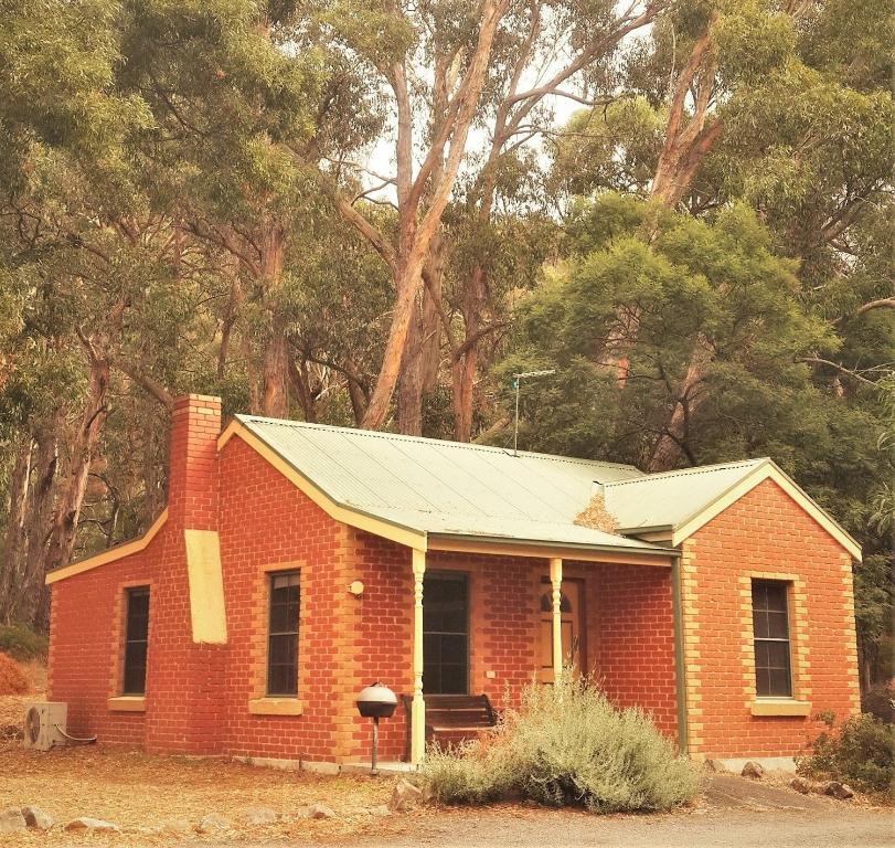 einem roten Backsteinhaus mit Metalldach in der Unterkunft Heatherlie Cottages Halls Gap in Halls Gap