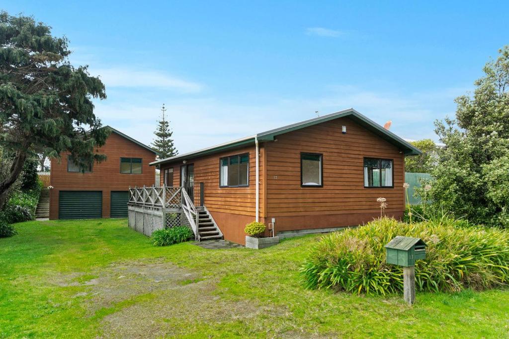 a wooden house with a yard in front of it at Heperi Haven - Waikanae Beach Holiday Home in Waikanae