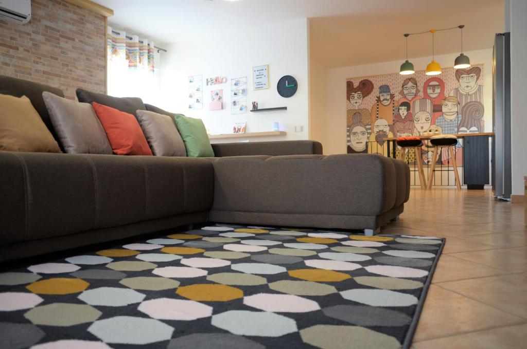 a living room with a couch and a rug at Murdegus Maison - Vivi il tuo Sogno in Sardegna! in Tortolì