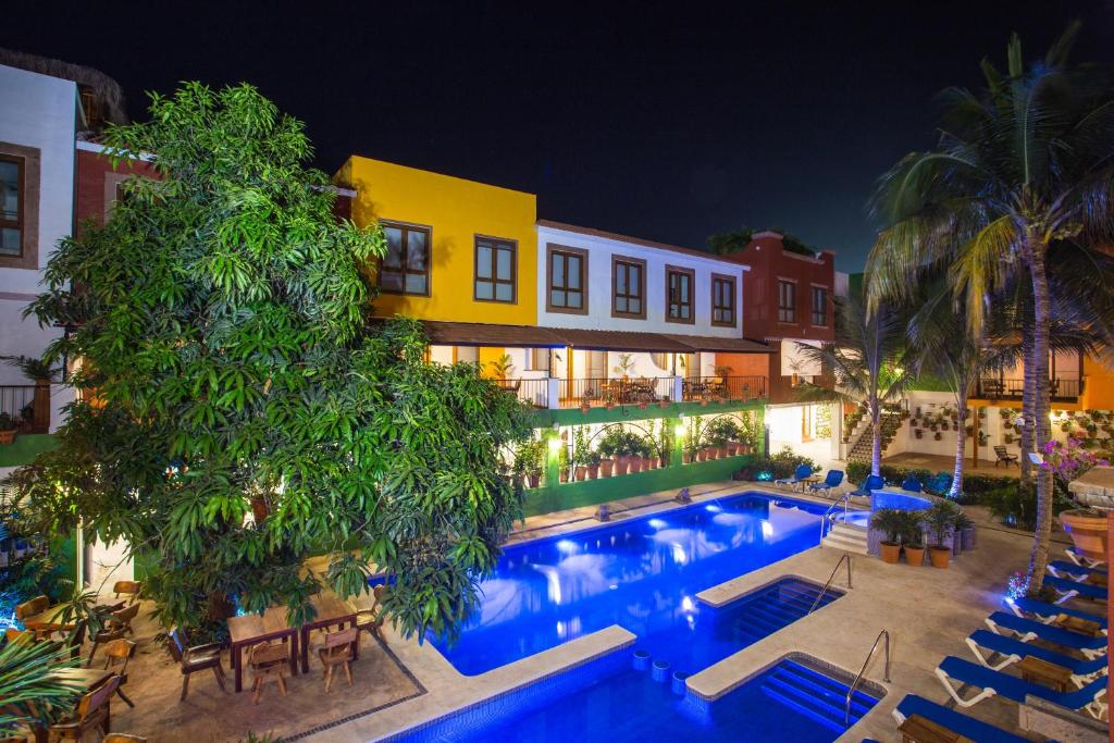 a hotel with a swimming pool at night at El Pueblito Sayulita - Colorful, Family and Relax Experience with Private Parking and Pool in Sayulita