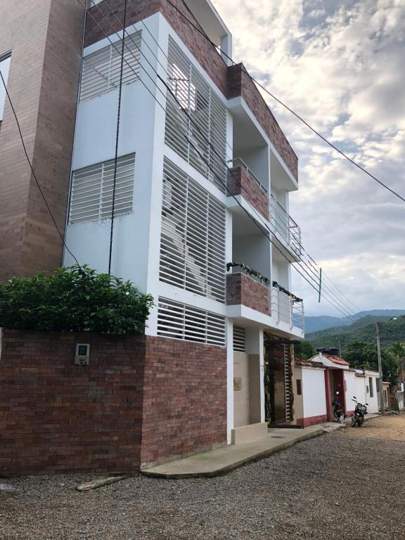 un edificio blanco con ventanas y pared de ladrillo en Econilonatural, en Anapoima