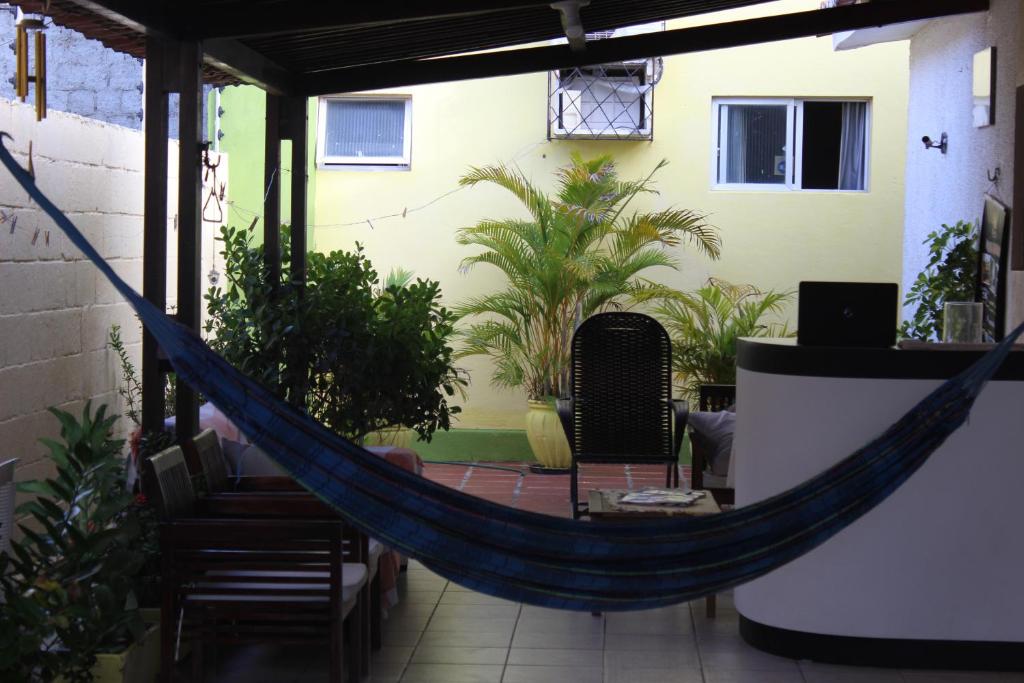 a hammock in the middle of a patio with plants at Pousada Zenite in Natal