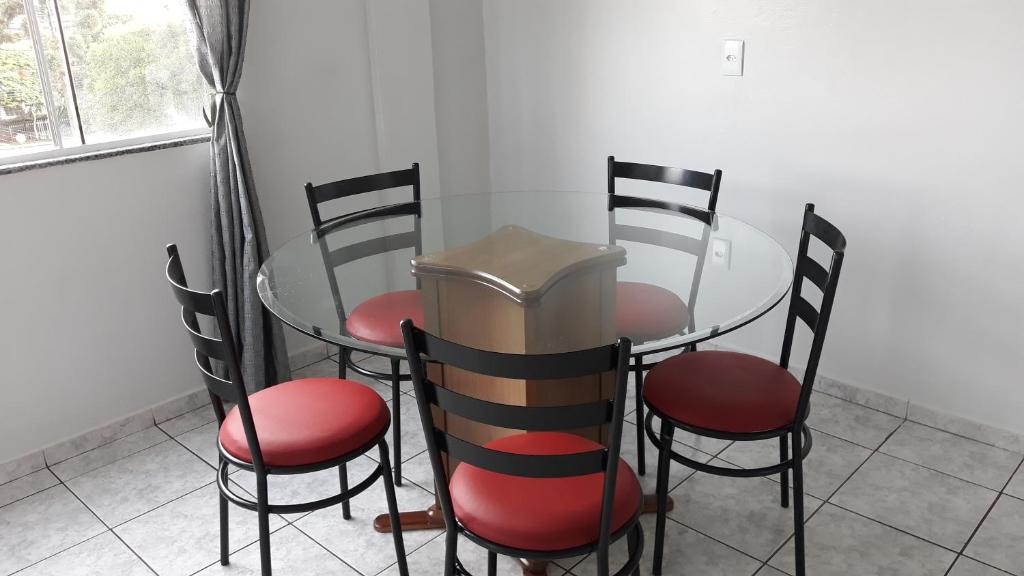 una mesa de cristal y 4 sillas en una habitación en Edifício Belio, en Cascavel