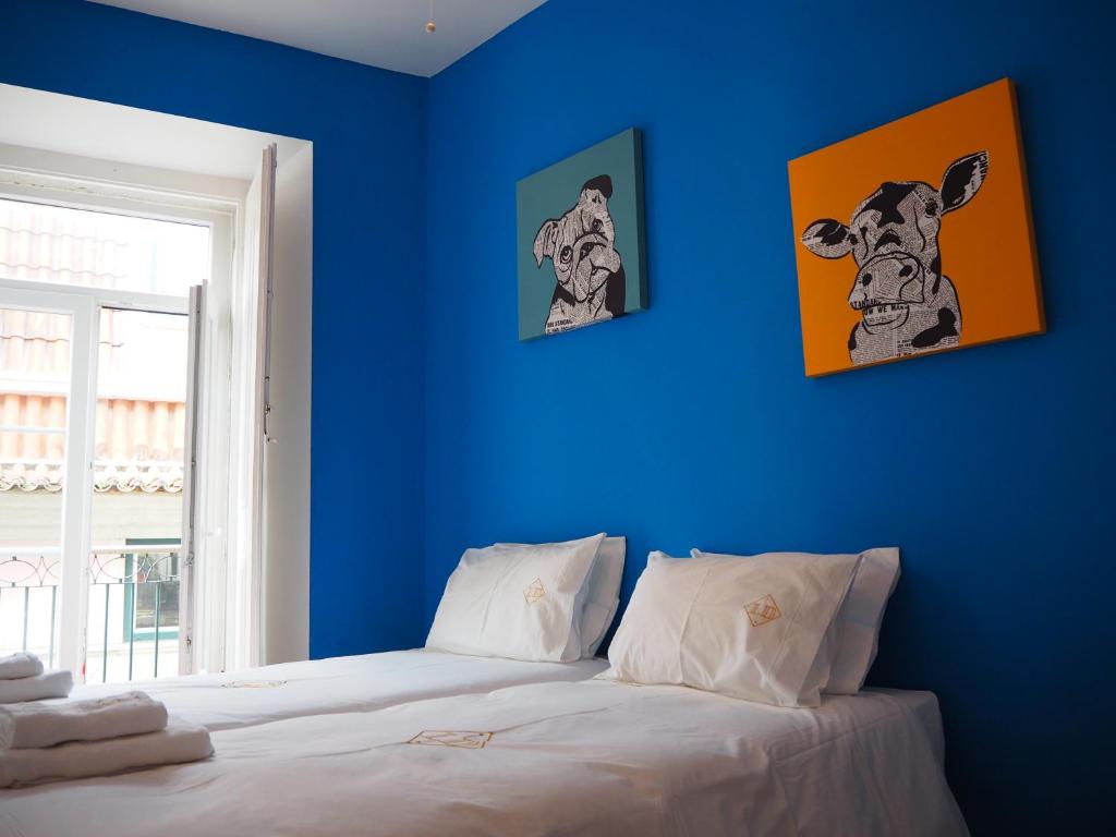 リスボンにあるLD Chiado - Super Central - ACの青い部屋(壁に2枚の写真が飾られたベッド付)
