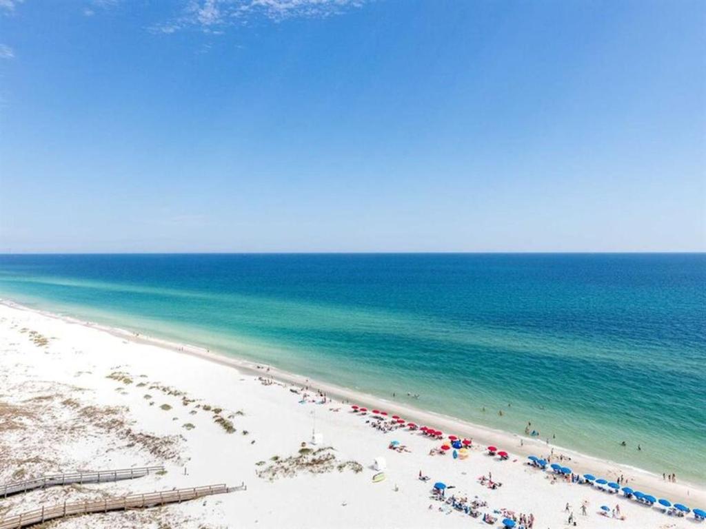 a beach with a lot of people and the ocean at Phoenix West II in Orange Beach