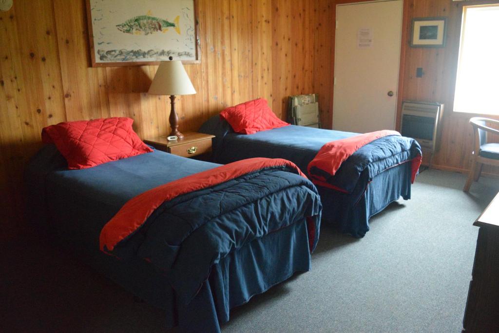a hotel room with two beds with red pillows at Zachar Bay Lodge in Kodiak