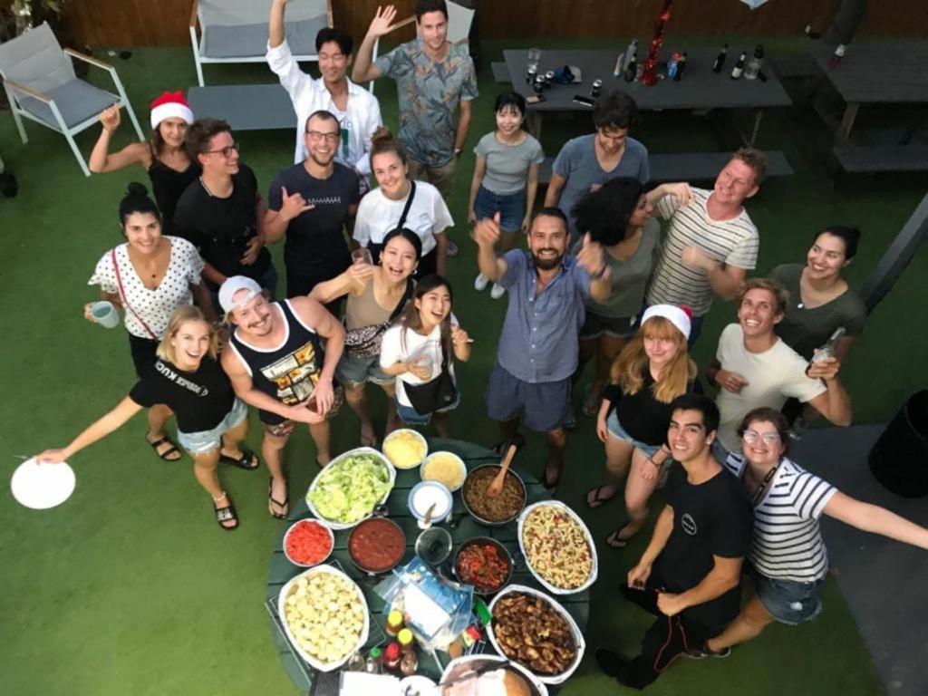 Un groupe de personnes autour d'une table avec de la nourriture dans l'établissement Mumma's Hostel Cairns, à Cairns