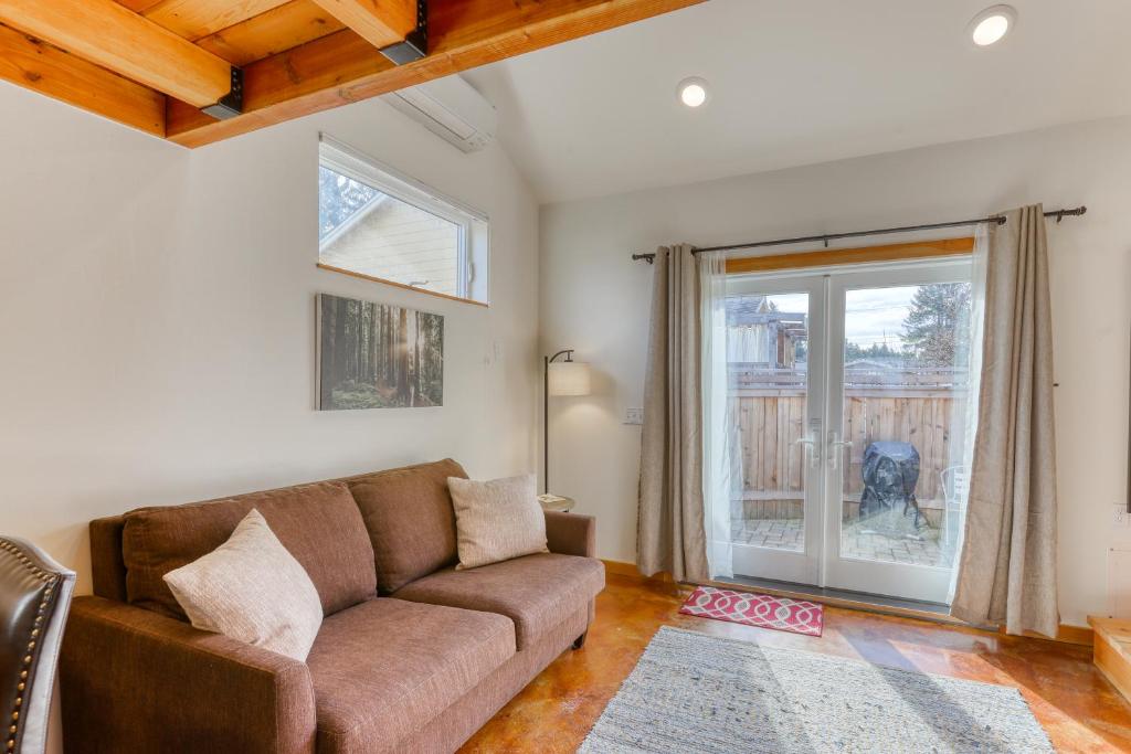 sala de estar con sofá marrón y ventana en Sequoia Cottage, en Eureka