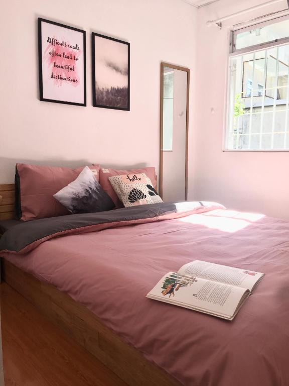 a bedroom with a bed with a book on it at Len’s hostel in Da Lat