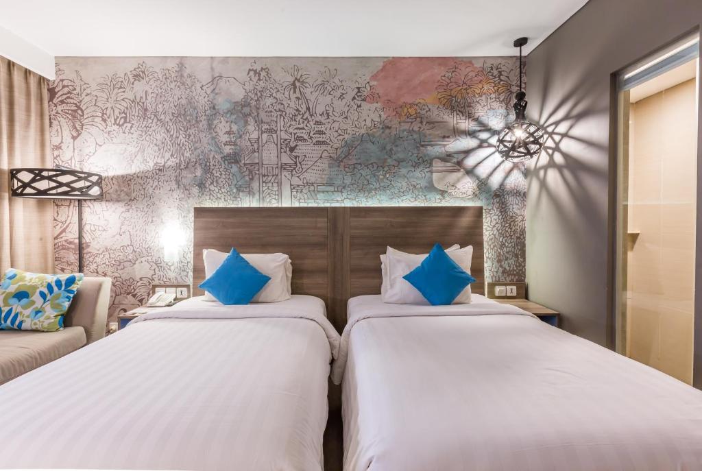 Un pat sau paturi într-o cameră la Wyndham Garden Kuta Beach Bali