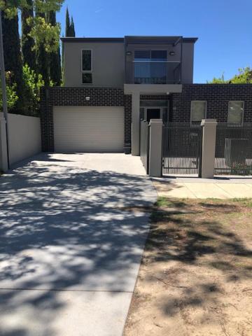 a large house with a garage with a fence at Central executive 4br townhouse in Albury