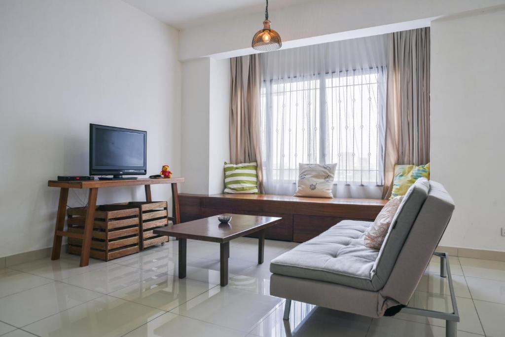 een woonkamer met een bank en een televisie bij Damen Subang by Widebed in Subang Jaya