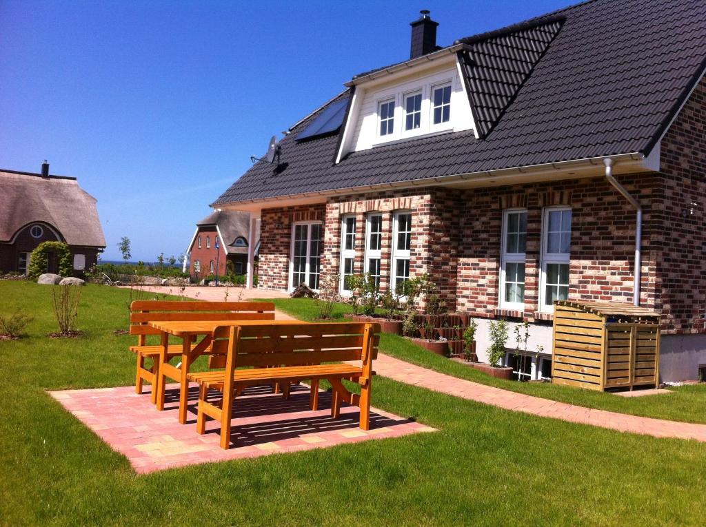 two benches sitting in front of a house at Haus Strandlaeufer in Dranske