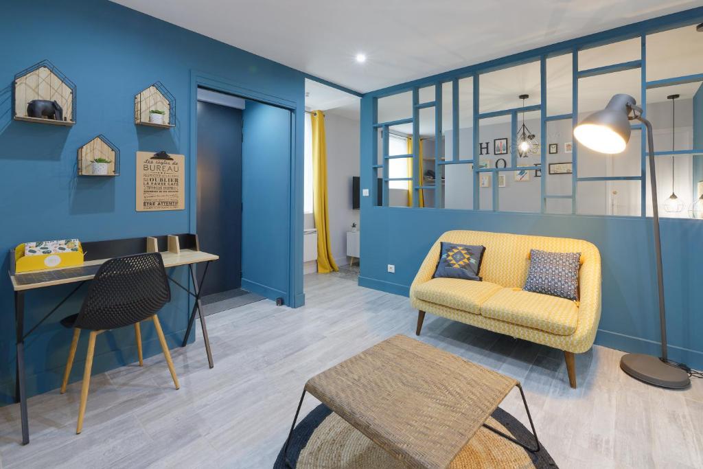 um quarto com paredes azuis e uma cadeira e uma mesa em Gîte de la Frête em Carvin