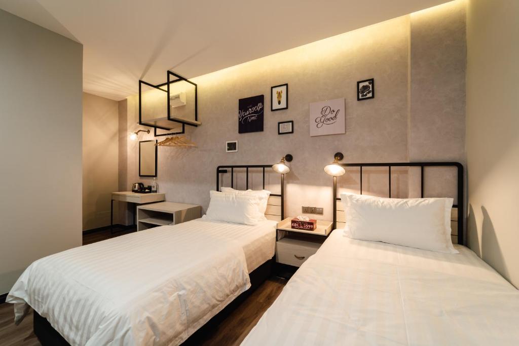 2 Betten in einem Zimmer mit 2 Lampen und 2 Betten sidx sidx sidx sidx in der Unterkunft SVOK Hotel in Tawau