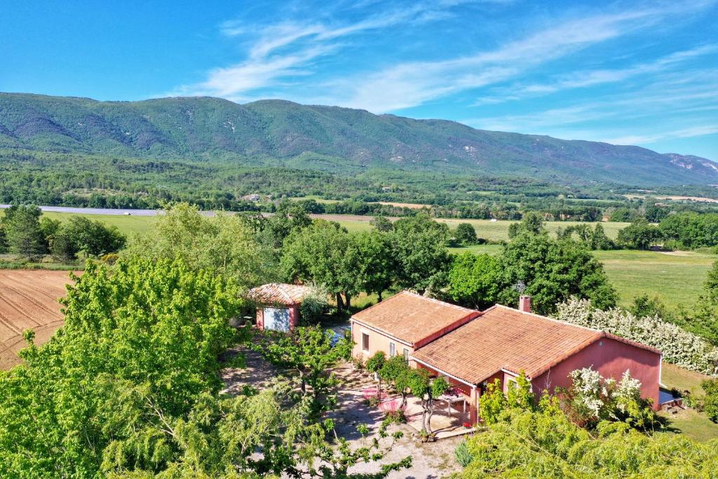 une vue aérienne sur une maison avec des montagnes en arrière-plan dans l'établissement Villa piscine face au grand luberon Cereste, à Céreste