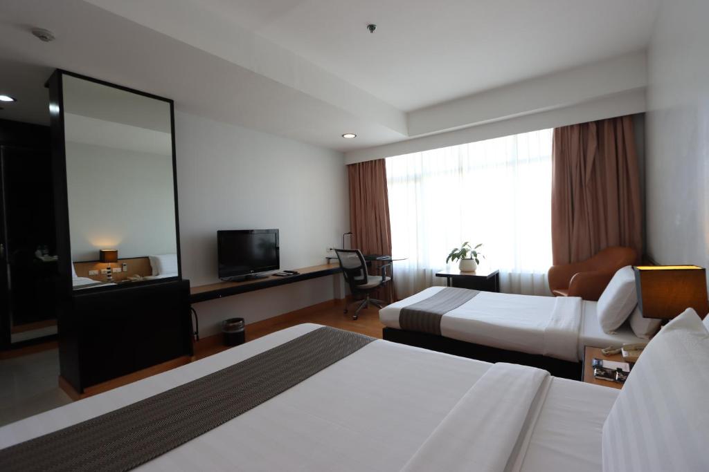 Postel nebo postele na pokoji v ubytování Paseo Premiere Hotel