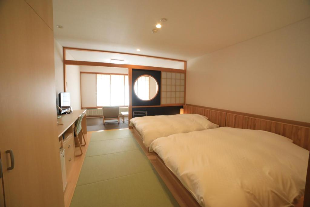 Postel nebo postele na pokoji v ubytování Kyukamura Nikko-Yumoto