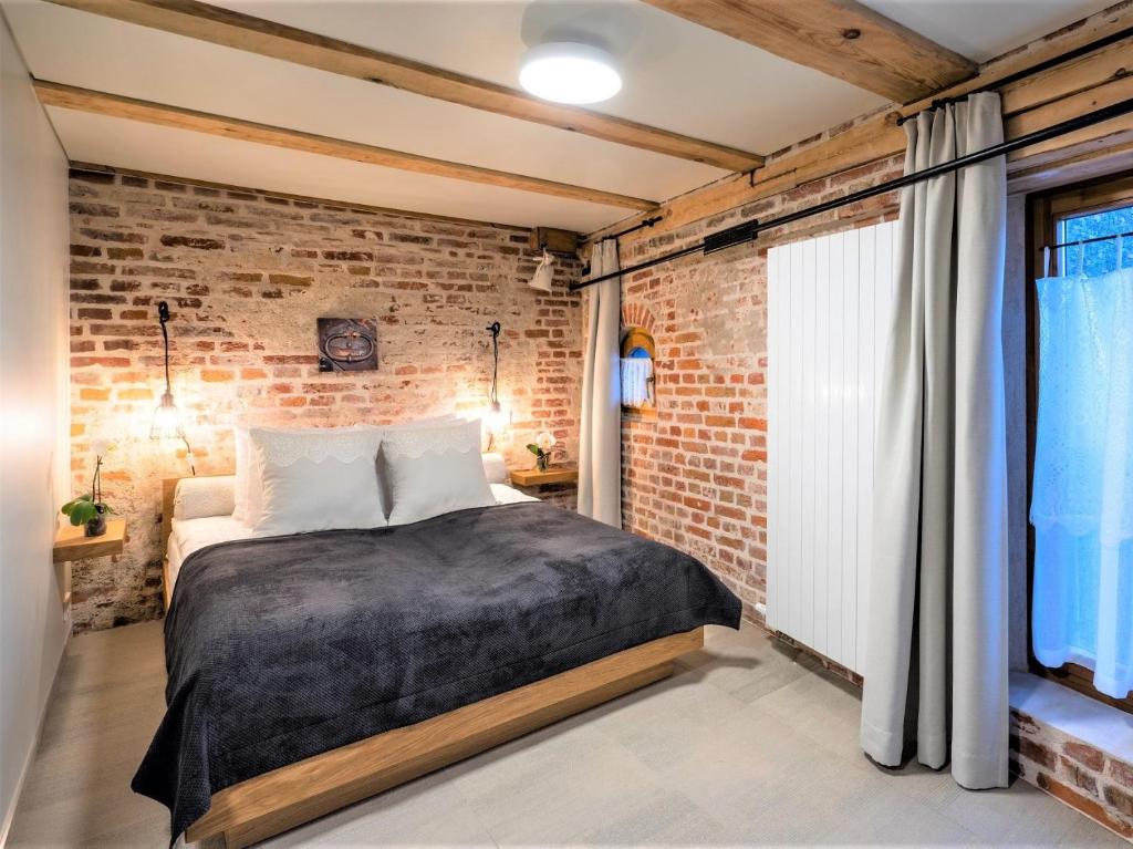 a brick walled bedroom with a bed and a window at Rixwell Old Riga Palace Hotel in Riga