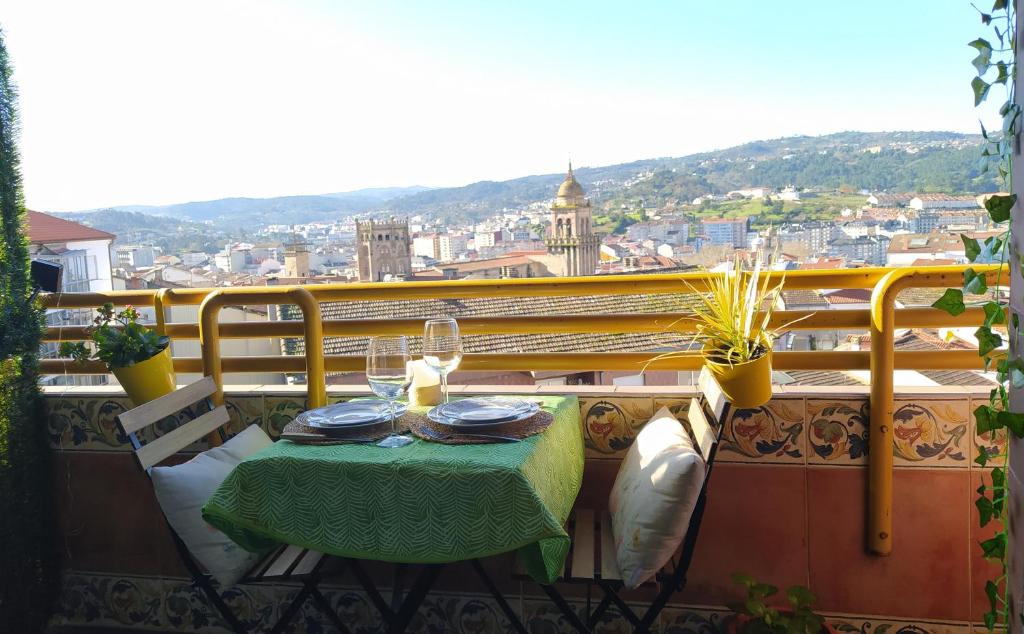 una mesa en un balcón con vistas a la ciudad en Casa FR, en Ourense