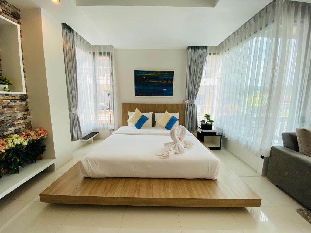 a bedroom with a large white bed and a couch at Buasri By Ohm in Patong Beach