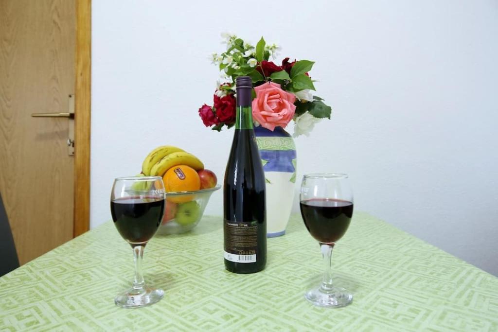 eine Flasche Wein und zwei Gläser auf dem Tisch in der Unterkunft Apartmani Mlinar9 #2 in Gornji Karin