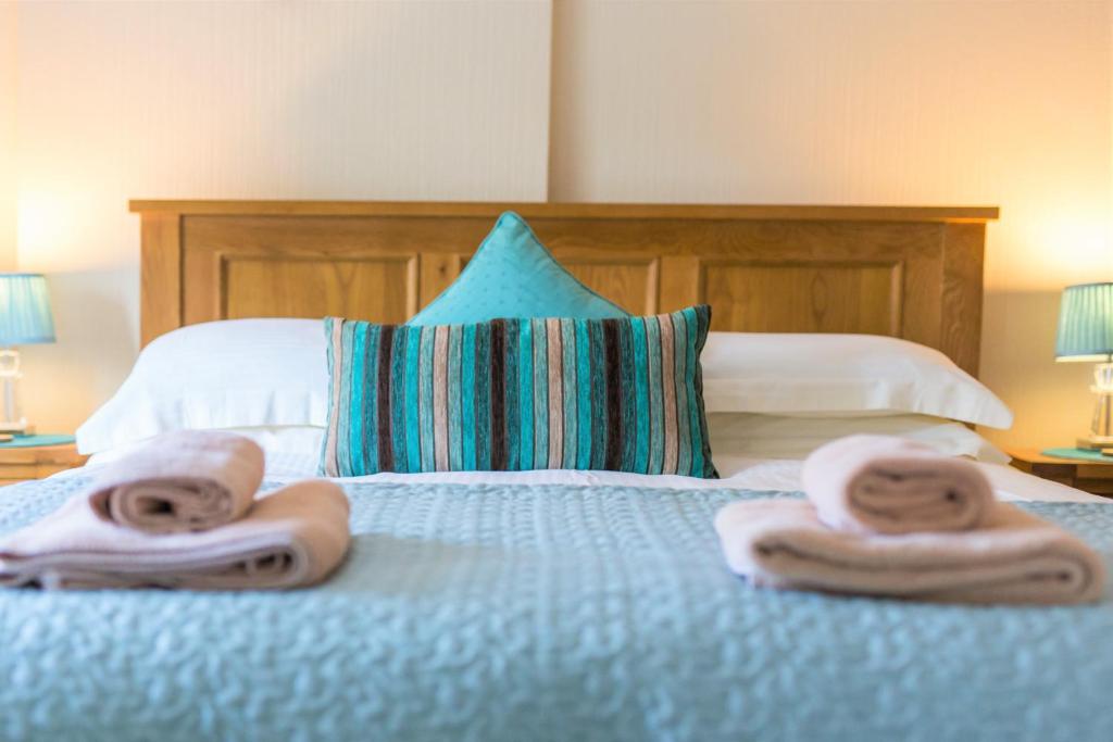 ein Schlafzimmer mit Handtüchern auf einem Bett mit Kissen in der Unterkunft Host & Stay - Daisy Cottage in Bamburgh