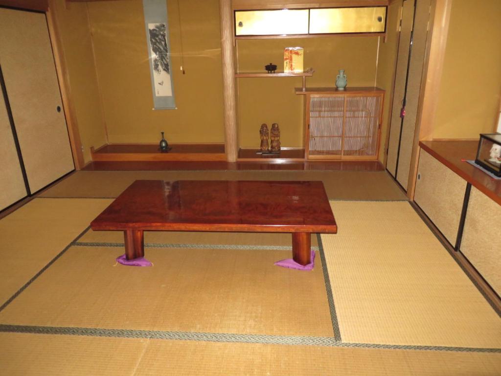 uma mesa de madeira sentada no topo de um piso em ゲストハウス山本 em Gifu