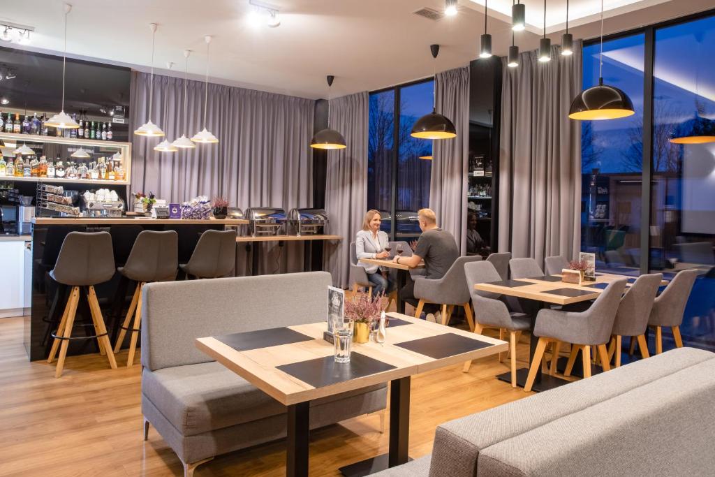 two people sitting at tables in a restaurant at Holistic in Solec-Zdrój