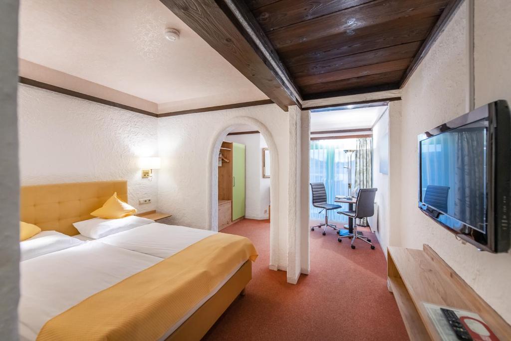 a hotel room with a bed and a flat screen tv at CONTEL Hotel in Koblenz