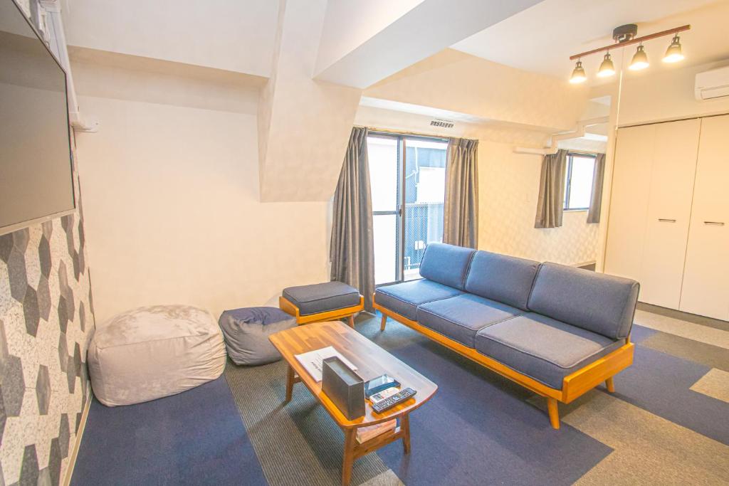 a living room with a couch and a table at AMP FLAT Nishijin 3 in Fukuoka