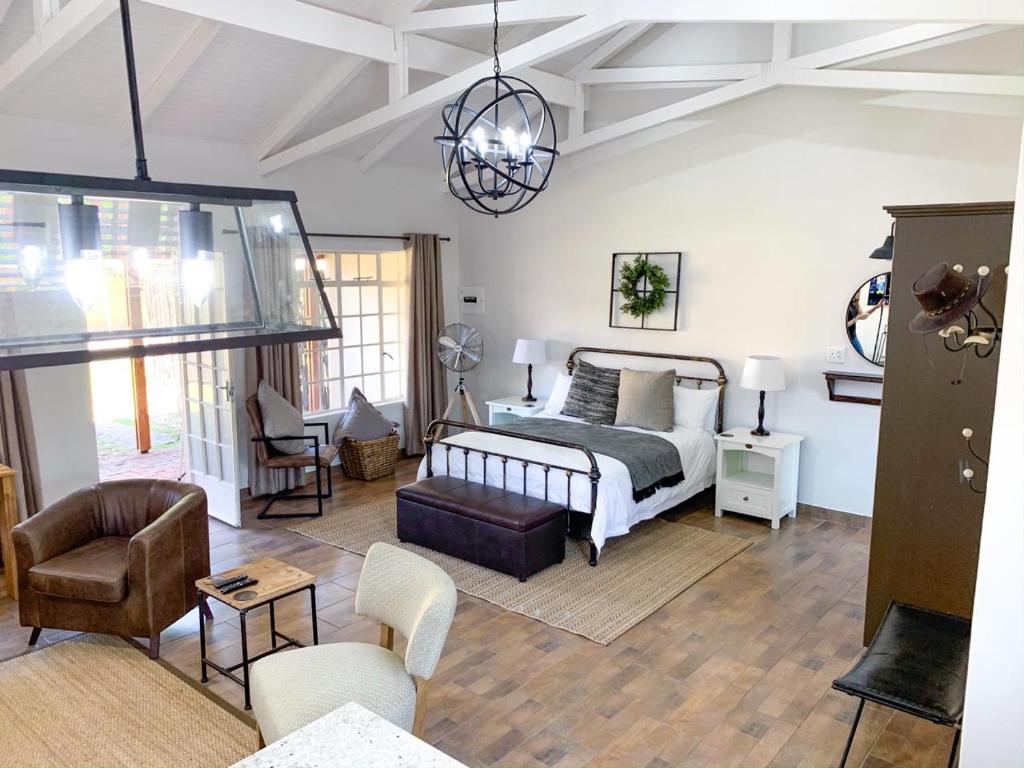 a bedroom with a bed and a living room at Modern Farm in Lichtenburg