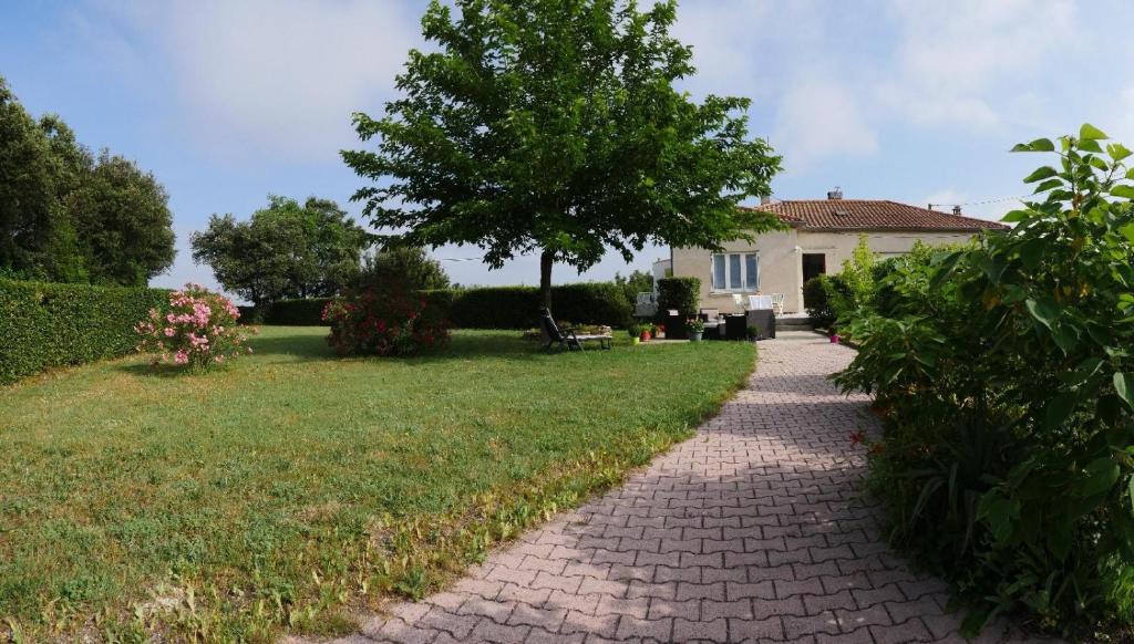 un camino de ladrillo que conduce a una casa con un árbol en VILLA BOIS LAUZON, en Orange