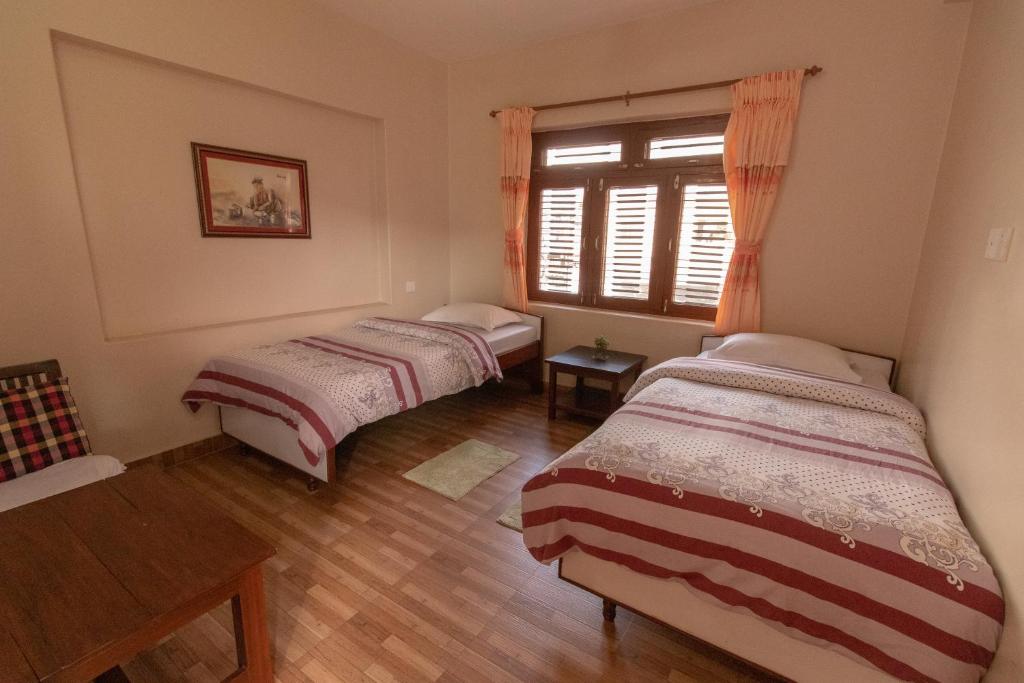 2 letti in una camera con finestra di New Tourist Guest House a Pokhara