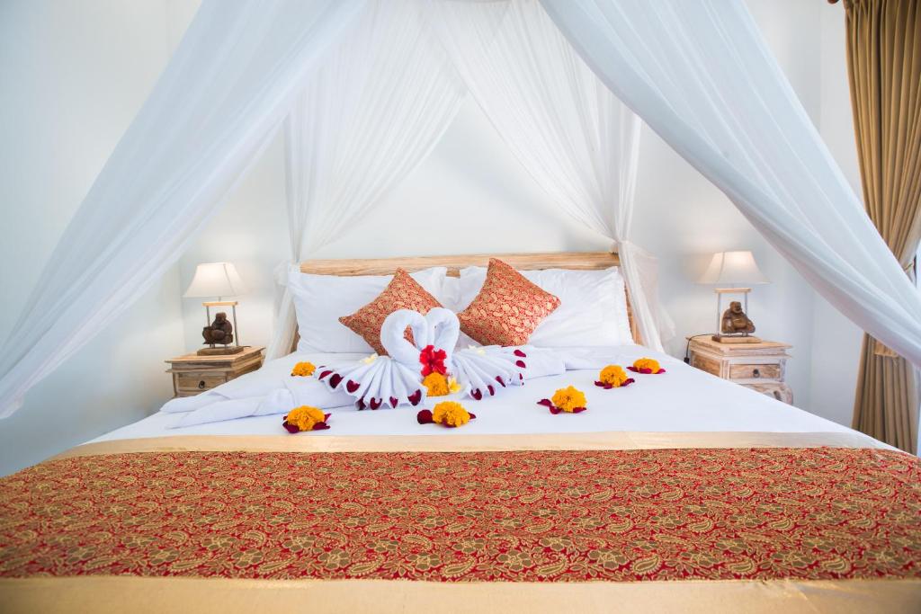 sypialnia z łóżkiem z kwiatami na nim w obiekcie Ubud Batan Nyuh bed & breakfast w mieście Ubud