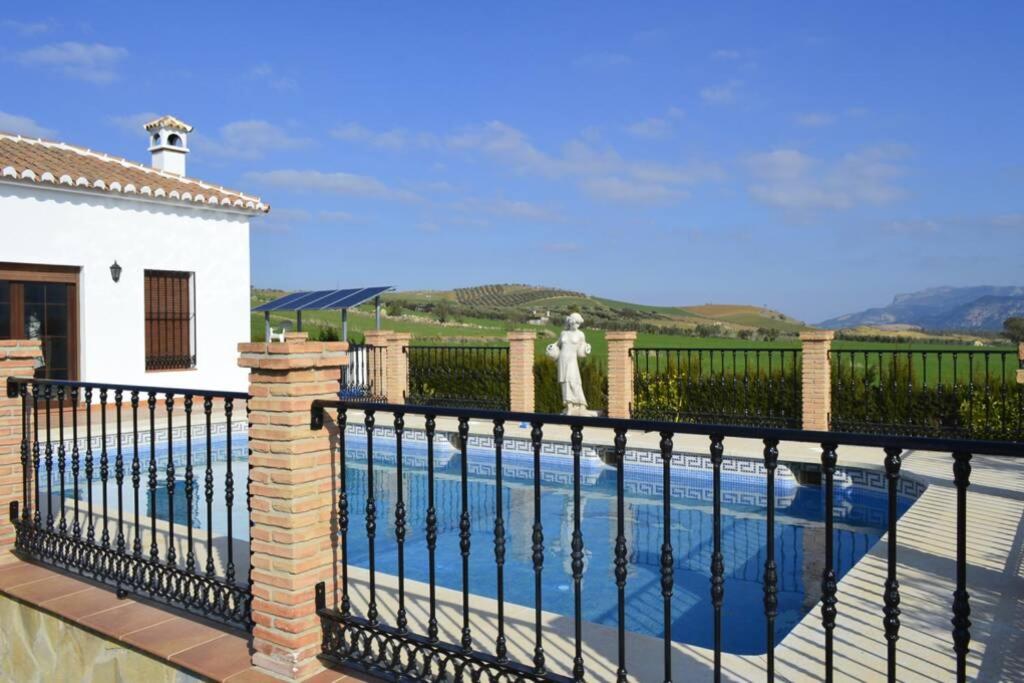 una piscina con una valla negra junto a una casa en Villa Rosales, en Ardales