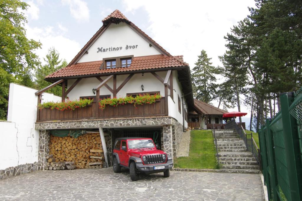 a red jeep parked in front of a building at Penzion Martinov Dvor in Žilina