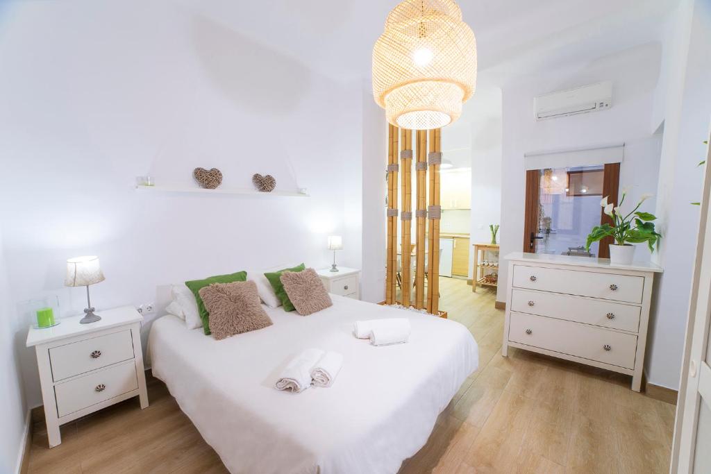 1 dormitorio blanco con 1 cama blanca grande y espejo en NICE LOFT IN MáLAGA HISTORICAL CENTER, en Málaga