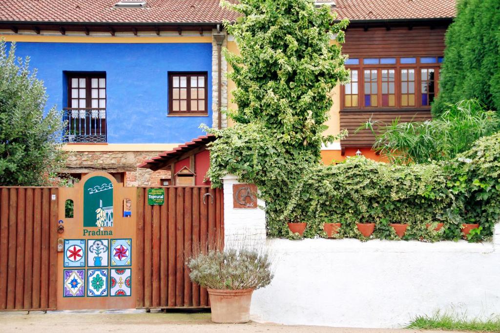 una casa azul con una valla y plantas en Casas Rurales Pradina I y II, en Luanco