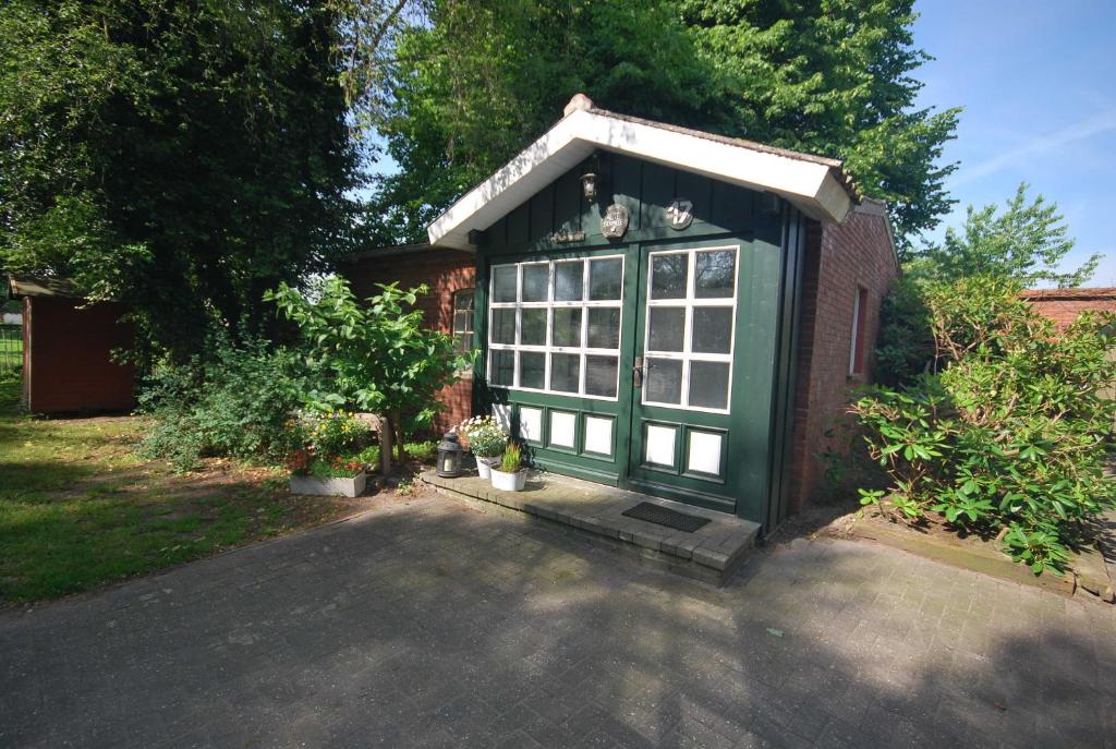 a small green greenhouse in the backyard of a house at Ferienhäuschen Alte Schmiede, 35647 in Uplengen