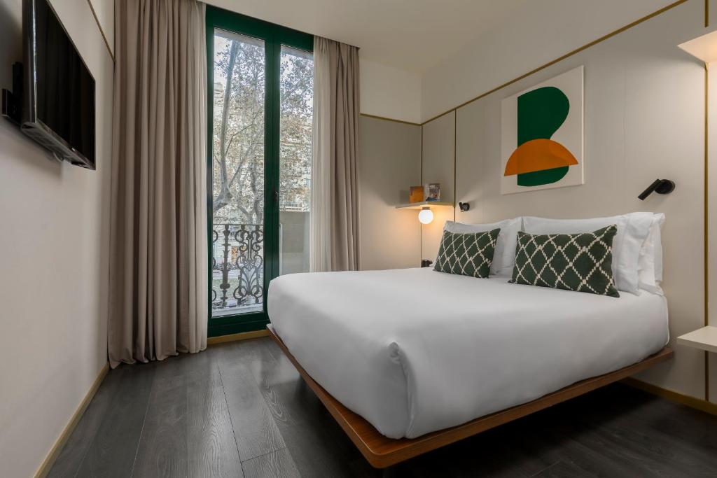 
a bedroom with a white bed and white walls at Be Mate Paseo de Gracia in Barcelona
