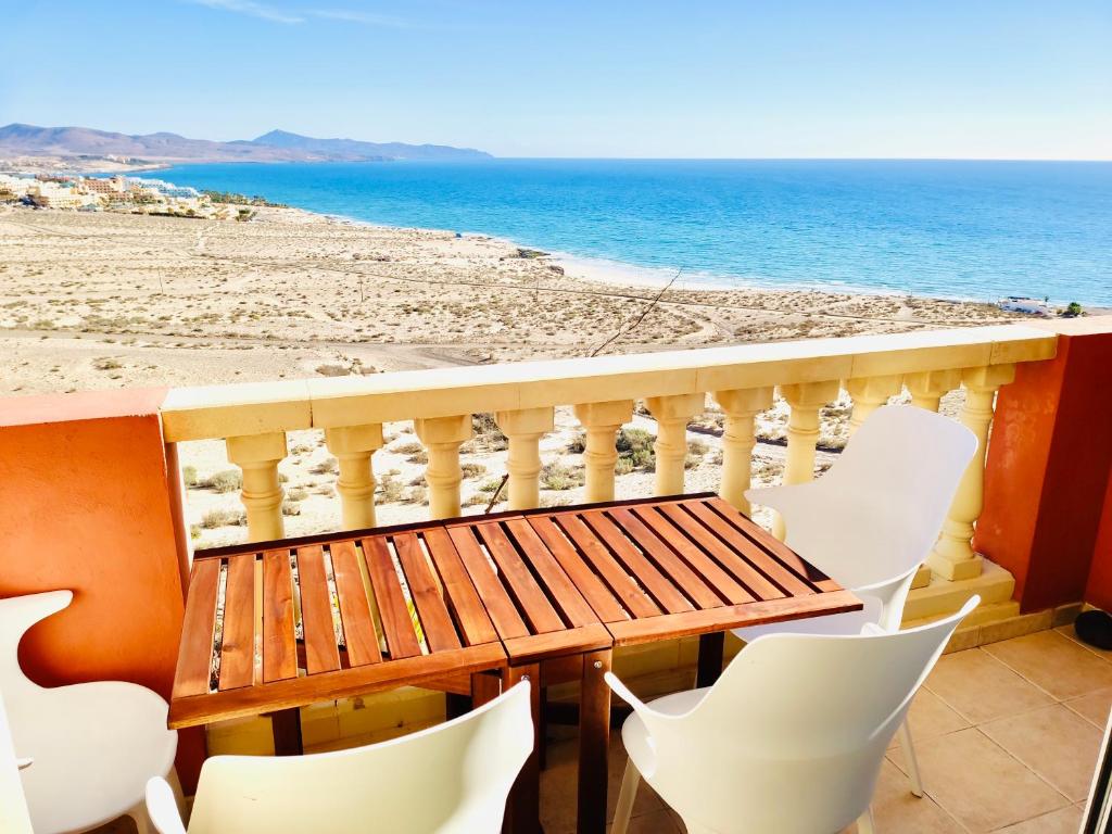 een balkon met een tafel en stoelen en het strand bij SMART-Beachview in Costa Calma