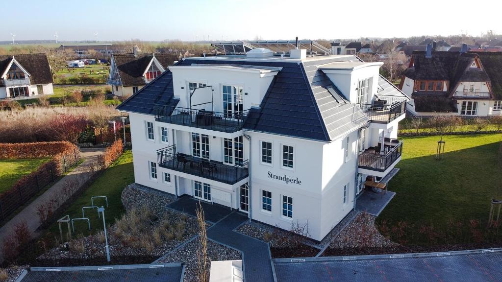 an aerial view of a white house with a black roof at Haus Strandperle in Börgerende-Rethwisch