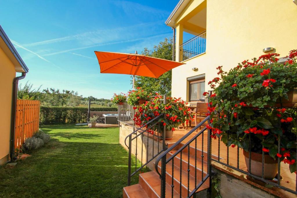 a patio with an orange umbrella in a yard at Villa Agata in Dajla
