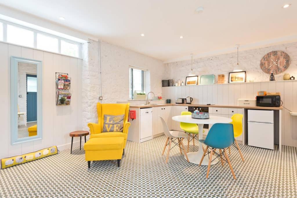 a kitchen with yellow chairs and a table at Connells Barn Conversion in Duleek
