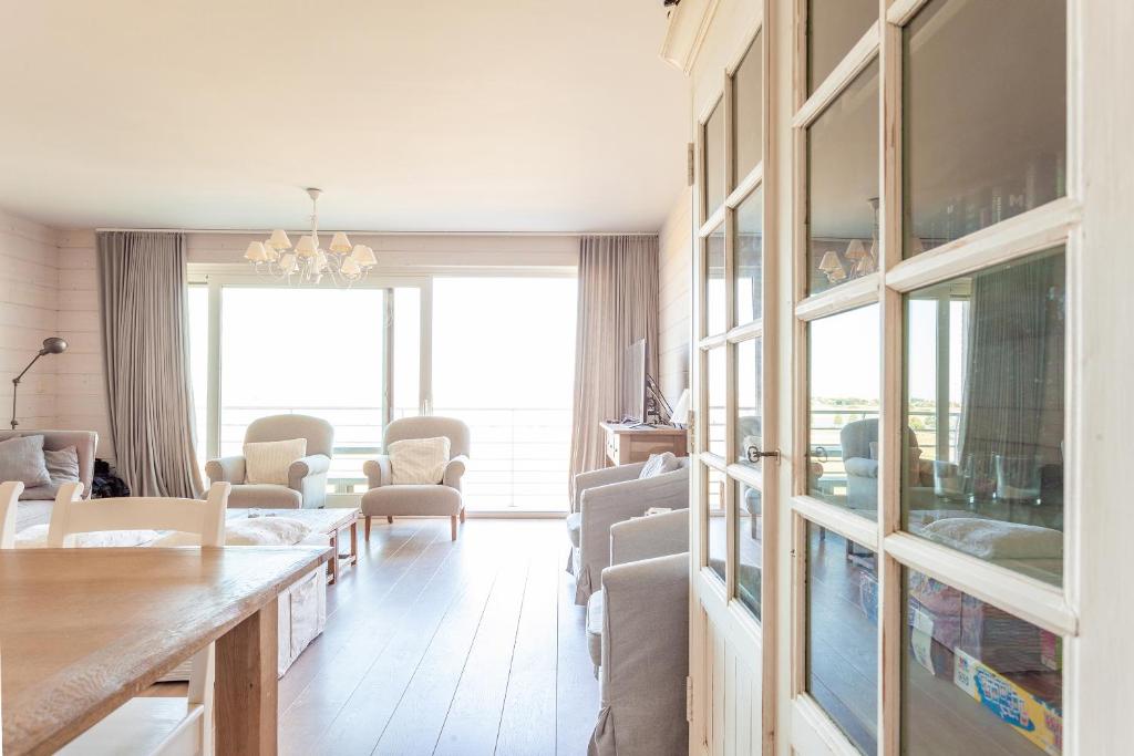 una sala de estar con una mesa y sillas en Apartment Zonnehaven, en Nieuwpoort