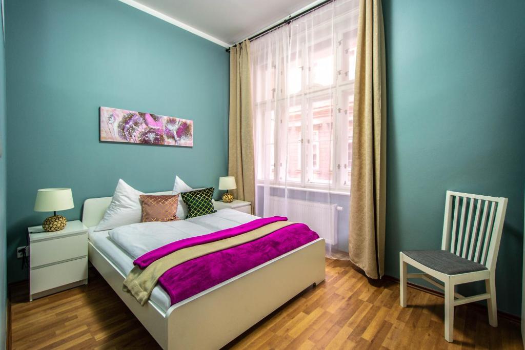 プラハにあるRuzova Apartment By Ruterraのベッドルーム1室(ベッド1台、窓、椅子付)